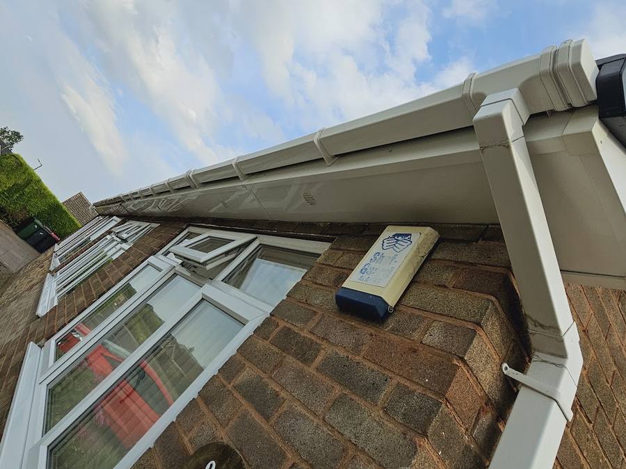 Bright white fascia, soffit and guttering after cleaning, against a blue sky