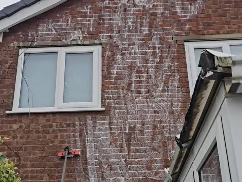 Soft wash treatment running down a heavily stained brick gable